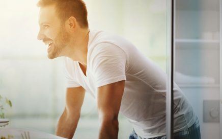 Man looking in to bathroom mirror considering a new razor